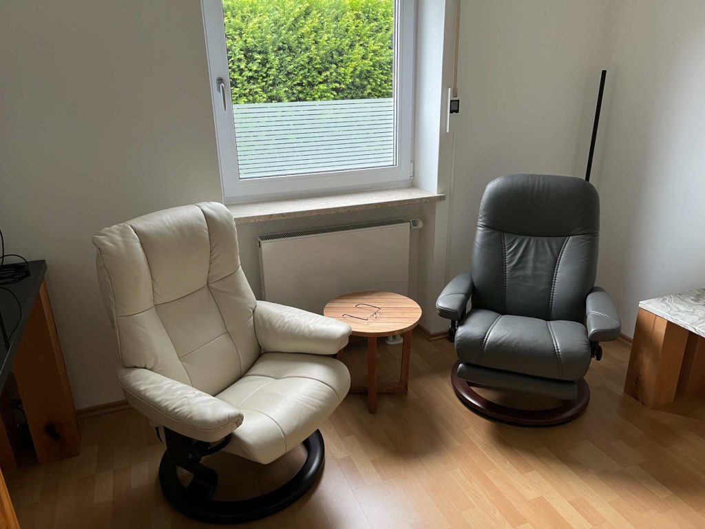 Ein Praxiszimmer mit einem weißen und einem schwarzen Sessel
